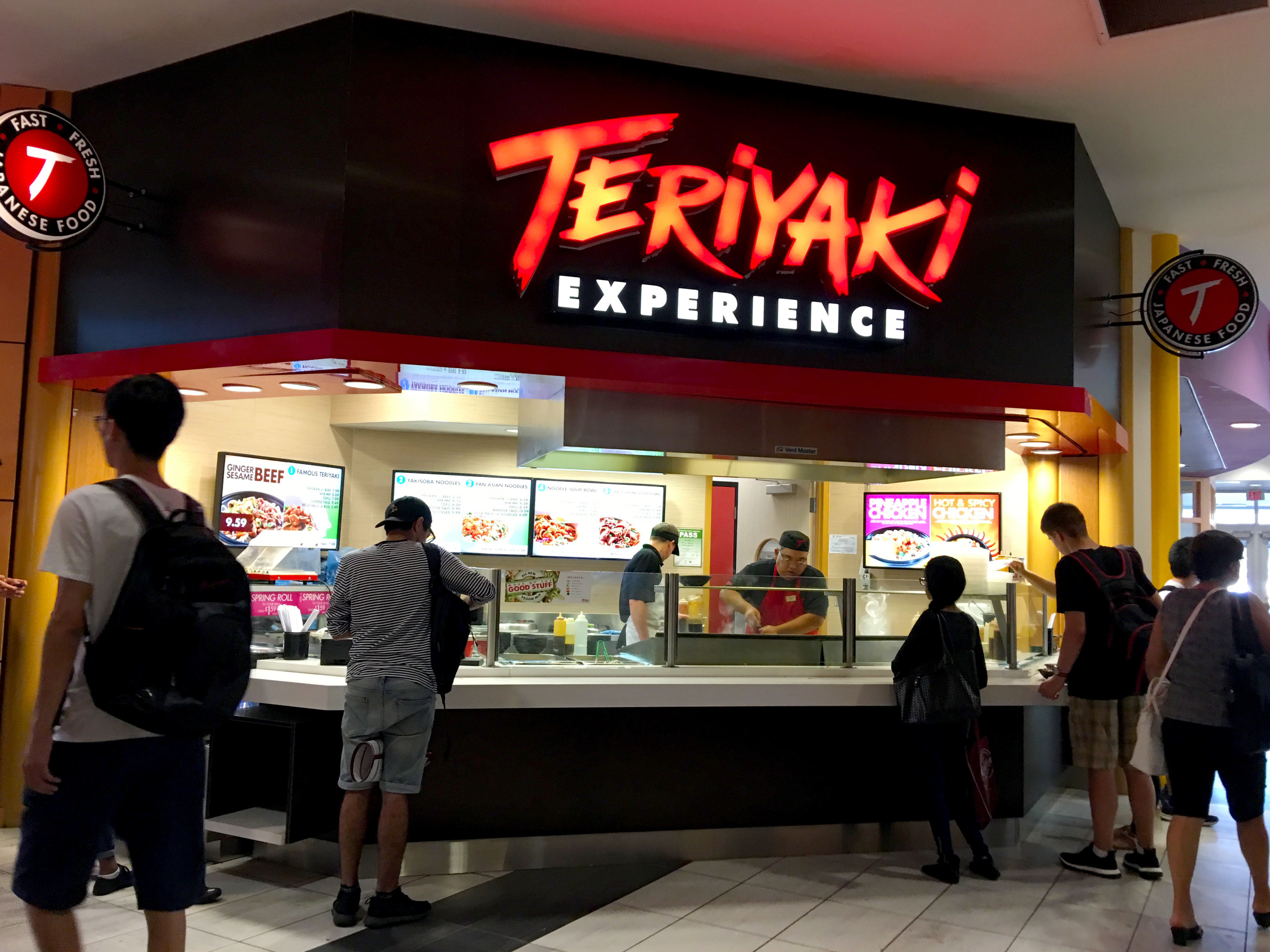 View of Teriyaki Experience restaurant with customers in front waiting