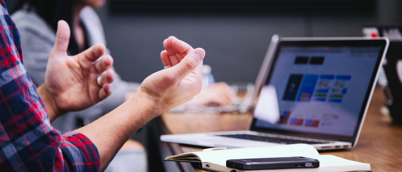 hands gesturing during meeting with laptop on a table