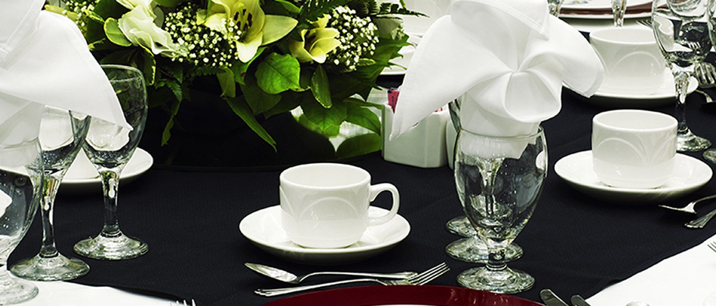 Hero banner close up photo of table arrangement with glasses, cutlery, and mugs